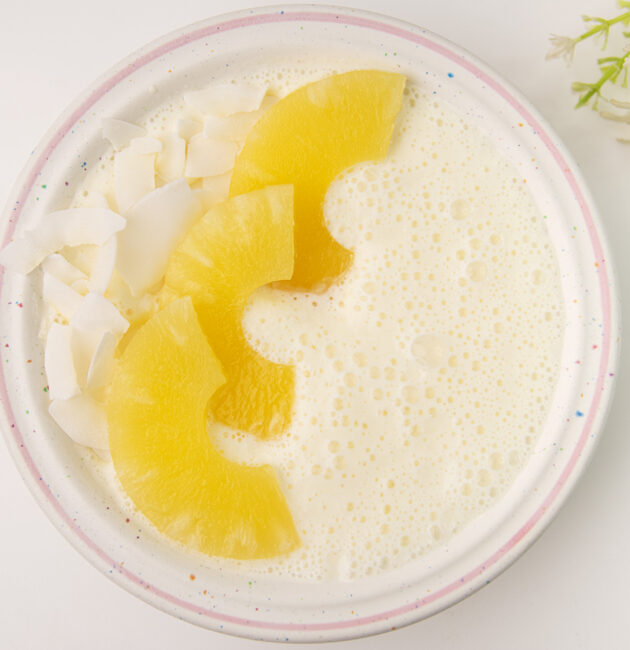 Smoothie u zdjeli sa grčkim jogurtom, ananasom i kokosovim čipsom